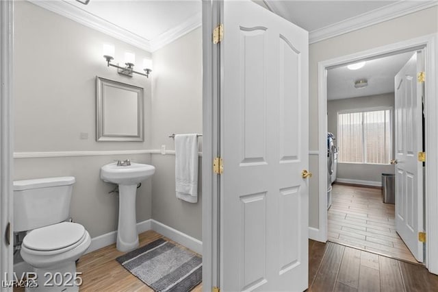 bathroom with toilet, crown molding, baseboards, and wood finished floors