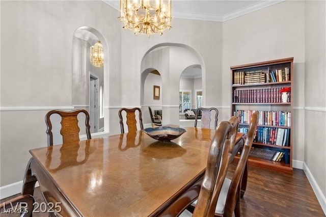 dining area with baseboards, ornamental molding, a chandelier, and wood finished floors