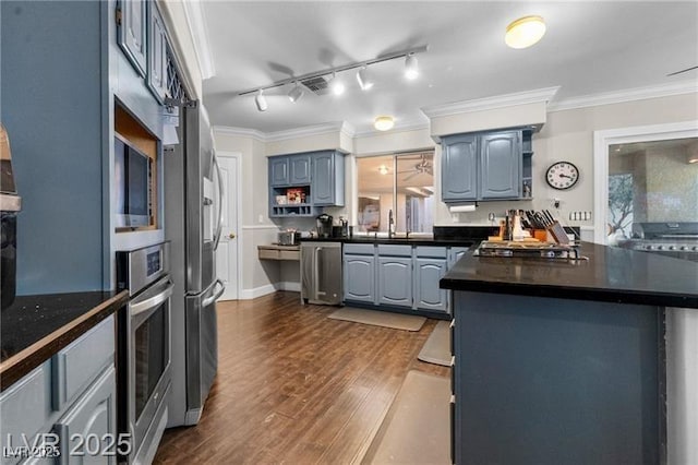 kitchen featuring dark countertops, a peninsula, stainless steel appliances, crown molding, and open shelves