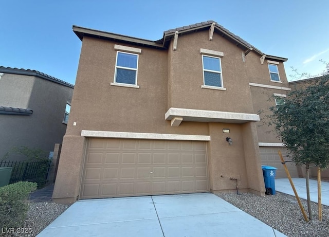 view of front of house with a garage, fence, concrete driveway, and stucco siding