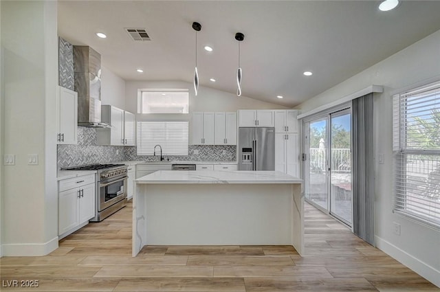 kitchen featuring a center island, high end appliances, visible vents, backsplash, and white cabinetry