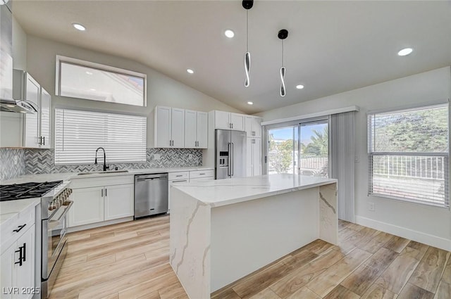 kitchen featuring a center island, a sink, light wood-style flooring, and high quality appliances