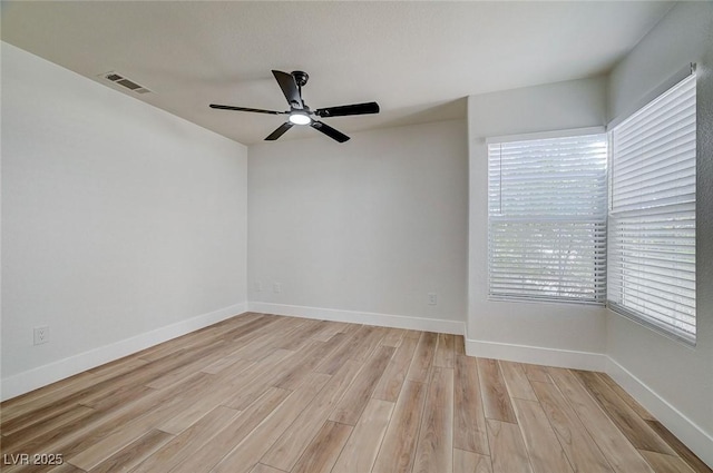 unfurnished room with baseboards, visible vents, ceiling fan, and light wood finished floors