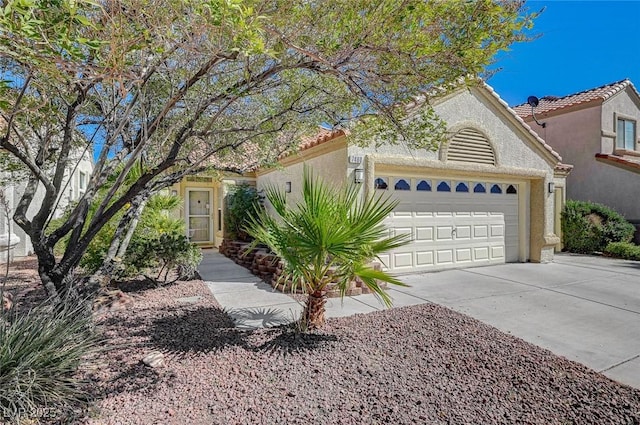 mediterranean / spanish-style home featuring a garage, concrete driveway, a tile roof, and stucco siding