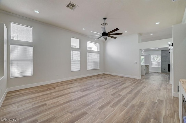 unfurnished living room with baseboards, a ceiling fan, visible vents, and light wood-style floors