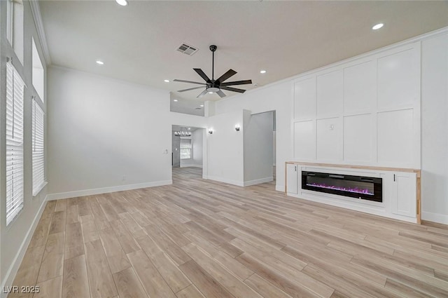 unfurnished living room with light wood finished floors, visible vents, a ceiling fan, and a glass covered fireplace