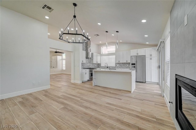 kitchen featuring a fireplace, stainless steel appliances, tasteful backsplash, visible vents, and a ceiling fan