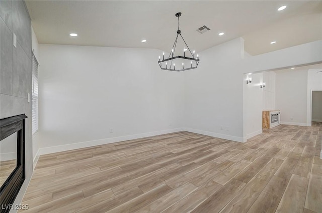 interior space featuring visible vents, a tiled fireplace, light wood-style flooring, and recessed lighting