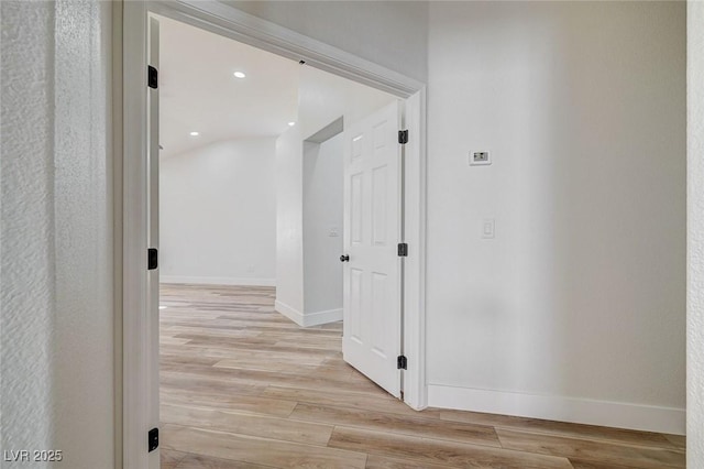 hall with recessed lighting, light wood-type flooring, and baseboards