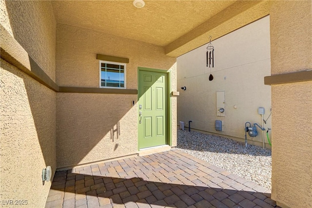 entrance to property featuring stucco siding