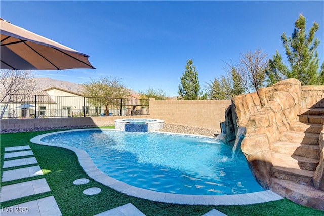 view of pool with fence and a pool with connected hot tub