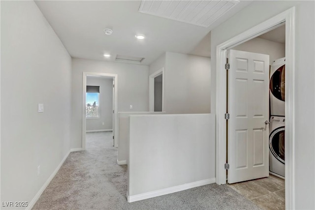 washroom featuring light carpet, laundry area, attic access, visible vents, and stacked washer / dryer