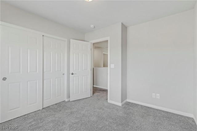 unfurnished bedroom with a closet, carpet, and baseboards