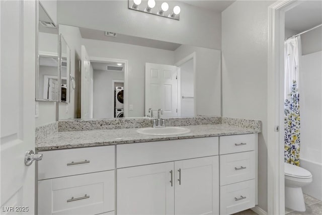 full bathroom featuring stacked washer / dryer, visible vents, vanity, and toilet