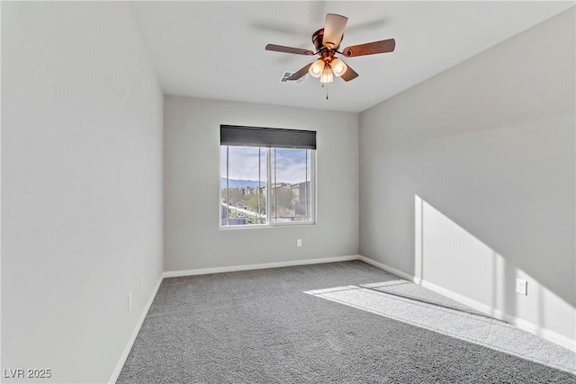 carpeted spare room featuring ceiling fan, visible vents, and baseboards