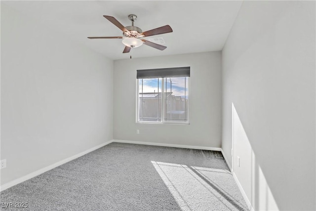 carpeted spare room with ceiling fan and baseboards