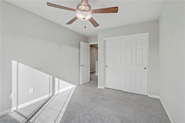 unfurnished bedroom with a ceiling fan, a closet, baseboards, and carpet flooring