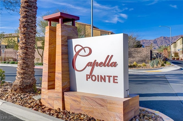 community / neighborhood sign with fence and a mountain view