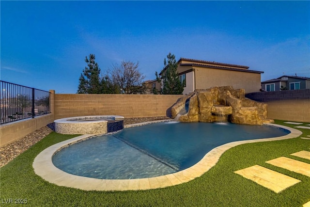 view of swimming pool with a fenced backyard, a pool with connected hot tub, and a water slide