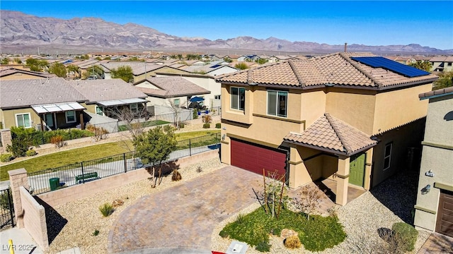 view of front facade with a tiled roof, fence, a mountain view, and stucco siding