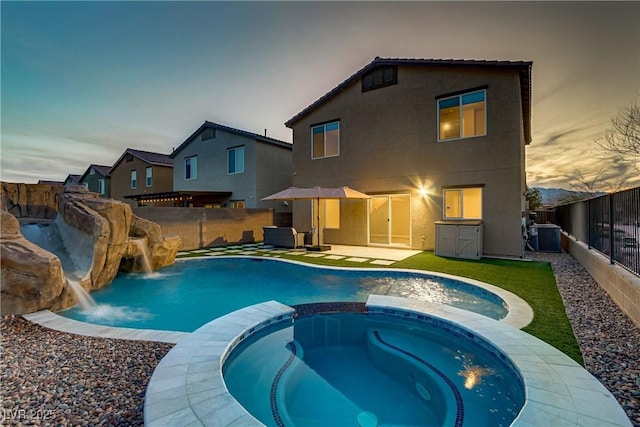 view of swimming pool with a pool with connected hot tub, a fenced backyard, and central air condition unit