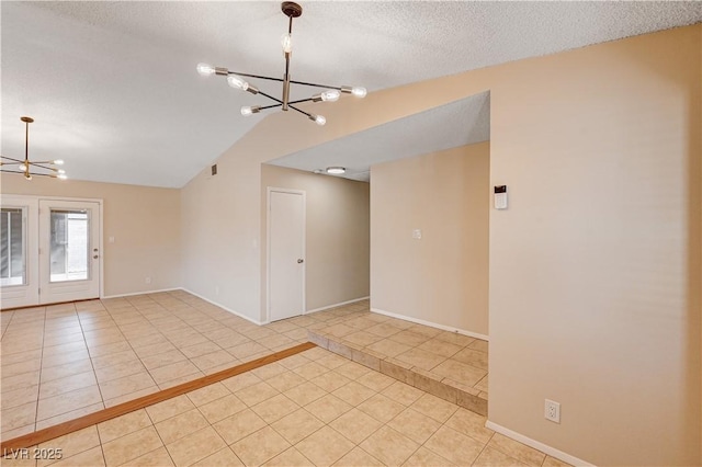 spare room featuring lofted ceiling, an inviting chandelier, tile patterned floors, and a textured ceiling