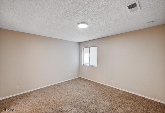 carpeted empty room featuring visible vents, baseboards, and a textured ceiling