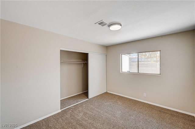 unfurnished bedroom featuring visible vents, baseboards, a closet, and carpet floors