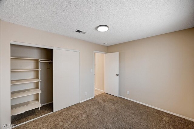 unfurnished bedroom featuring visible vents, baseboards, carpet, a closet, and a textured ceiling