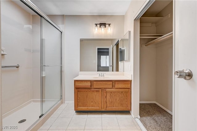 bathroom with baseboards, a stall shower, vanity, and tile patterned flooring