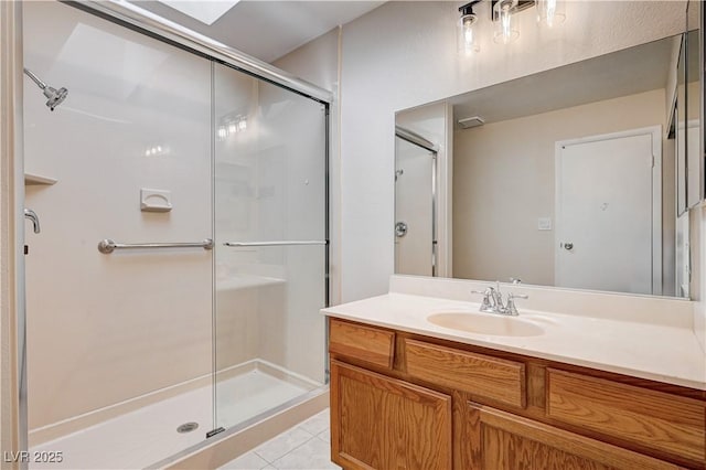 full bath featuring tile patterned flooring, vanity, and a stall shower