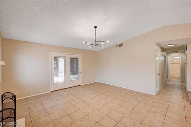 empty room featuring a notable chandelier, visible vents, a textured ceiling, and vaulted ceiling