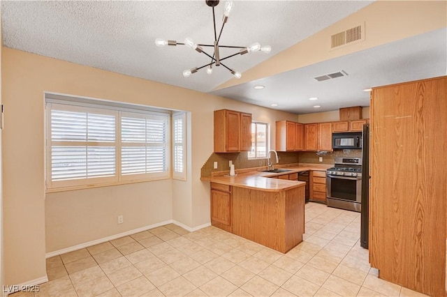 kitchen with stainless steel gas range oven, visible vents, a sink, a peninsula, and black microwave