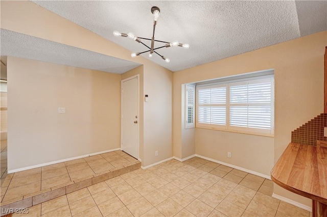 interior space featuring tile patterned flooring, a textured ceiling, and a chandelier