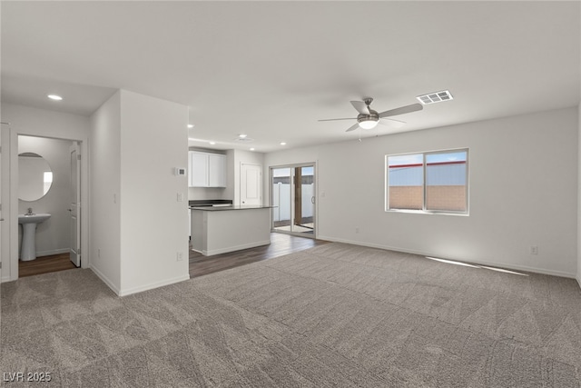 unfurnished living room with baseboards, carpet flooring, visible vents, and recessed lighting