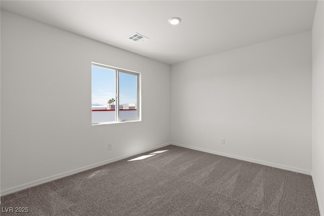 carpeted spare room featuring baseboards and visible vents