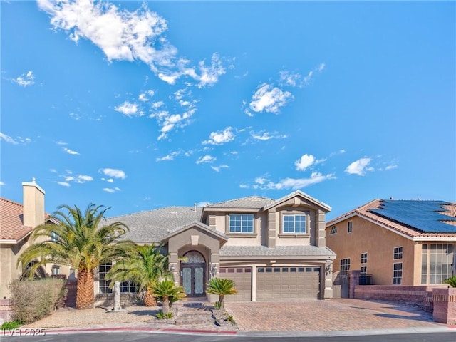 view of front of house featuring a garage, decorative driveway, and stucco siding