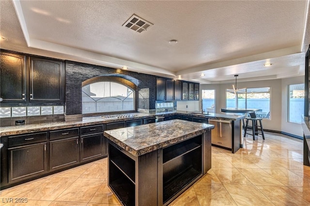 kitchen with stainless steel appliances, visible vents, backsplash, open shelves, and a tray ceiling