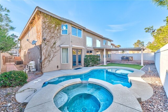 view of pool featuring a patio area, a fenced backyard, central AC, and french doors