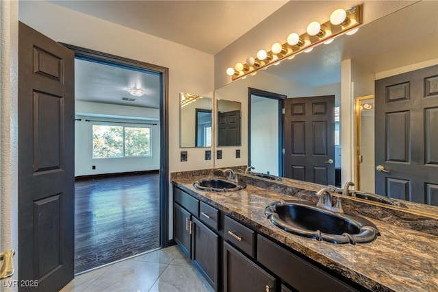 full bathroom featuring double vanity, a sink, and tile patterned floors