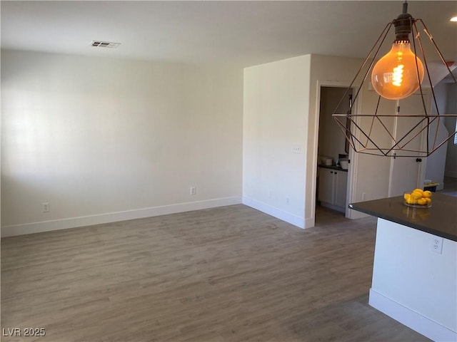 interior space with visible vents, baseboards, and wood finished floors