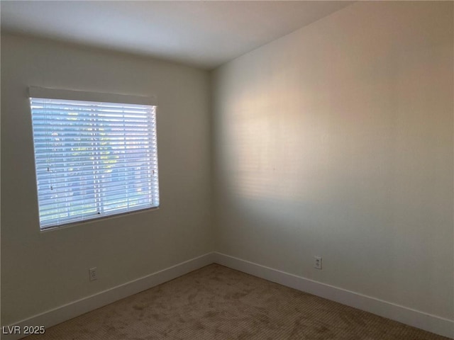 unfurnished room featuring baseboards and light colored carpet