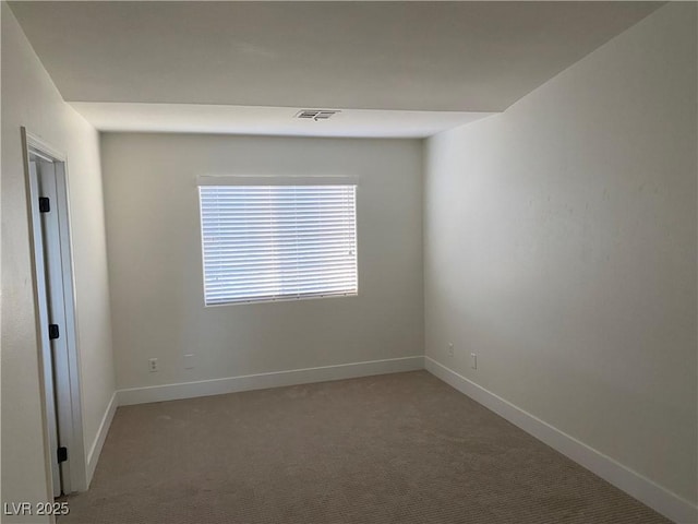 carpeted empty room with visible vents and baseboards