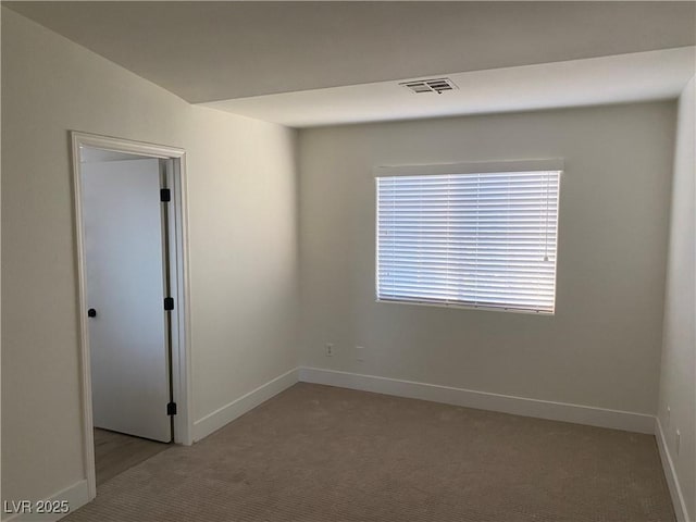 spare room featuring light carpet, baseboards, and visible vents