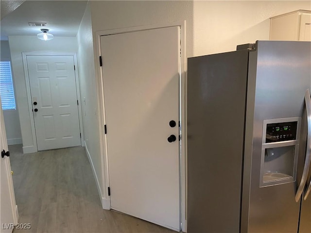 kitchen with white cabinetry, baseboards, visible vents, stainless steel fridge with ice dispenser, and light wood finished floors