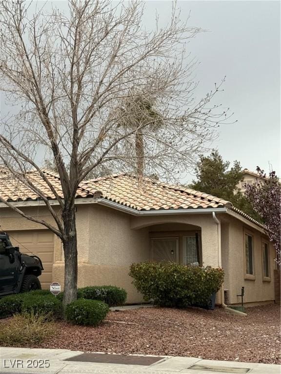 view of side of home featuring a tiled roof and stucco siding