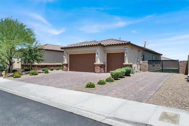 view of front of home featuring an attached garage, stone siding, decorative driveway, a gate, and stucco siding