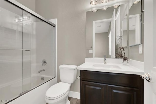 full bath with shower / bath combination with glass door, vanity, and toilet