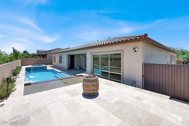 view of pool with a patio, a fenced backyard, and a pool with connected hot tub