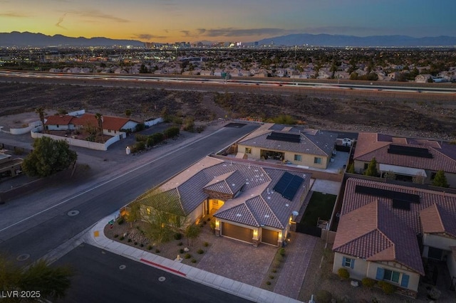 aerial view at dusk featuring a residential view and a mountain view